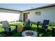 Inviting backyard oasis featuring Adirondack chairs, a fire pit, and manicured artificial grass at 6907 E Palm Ln, Scottsdale, AZ 85257