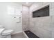 Modern bathroom with tiled shower featuring black hexagon mosaic tiles and a built-in niche at 6907 E Palm Ln, Scottsdale, AZ 85257