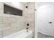 Stylish bathtub with shower, niche, and white tile in the remodeled bathroom at 6907 E Palm Ln, Scottsdale, AZ 85257