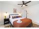A bedroom features a ceiling fan, a queen bed, reading lights, and white walls at 6907 E Palm Ln, Scottsdale, AZ 85257