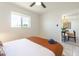 Bright bedroom with white walls, a ceiling fan, window, and view to dining area at 6907 E Palm Ln, Scottsdale, AZ 85257