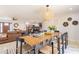 Open concept dining area showcasing modern light fixture, wood table, seating, and white countertops at 6907 E Palm Ln, Scottsdale, AZ 85257