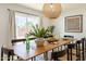 Bright dining room featuring a wooden table, modern lighting, and a view of the backyard at 6907 E Palm Ln, Scottsdale, AZ 85257