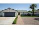 Charming single-story home featuring a landscaped front yard, brick walkway, and a spacious two-car garage at 6907 E Palm Ln, Scottsdale, AZ 85257