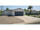 Single-story home featuring a two-car garage, desert landscaping, and a well-maintained lawn at 6907 E Palm Ln, Scottsdale, AZ 85257