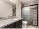 Bathroom boasts vanity with granite counters, a sink, mirror and tiled shower with glass doors at 7126 N 19Th Ave # 228, Phoenix, AZ 85021