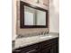 Bathroom features a granite countertop, undermount sink, a wood framed mirror, and wood look accent wall at 7126 N 19Th Ave # 228, Phoenix, AZ 85021
