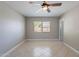 Neutral bedroom with ceiling fan, tiled floor, window, and access to the rest of the house at 719 W Pampa Ave, Mesa, AZ 85210