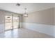 Dining room with tile flooring, sliding glass door, wainscoting and modern light fixture at 719 W Pampa Ave, Mesa, AZ 85210
