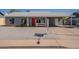 Charming single-story home featuring a bright red door, desert landscaping, and a covered carport at 719 W Pampa Ave, Mesa, AZ 85210