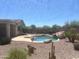 Inviting backyard featuring a pristine pool, rock waterfall, and drought-tolerant landscaping at 7327 W Donner Dr, Laveen, AZ 85339
