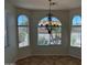 Elegant dining area enhanced by tile flooring, an ornate chandelier, and arched windows at 7327 W Donner Dr, Laveen, AZ 85339