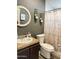 Bathroom features a white toilet, shower curtain, and a sink with dark brown cabinetry at 8218 S 7Th St # Ofc, Phoenix, AZ 85042