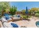 Inviting backyard with cozy seating, a pool view, and lush desert landscaping at 8447 W Tether Trl, Peoria, AZ 85383
