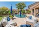 Inviting backyard oasis featuring a pool with a rock waterfall and comfortable lounge seating at 8447 W Tether Trl, Peoria, AZ 85383