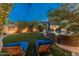 Backyard retreat with a serene pool view, comfortable lounge seating, and lush landscaping creating a relaxing outdoor space at 8447 W Tether Trl, Peoria, AZ 85383