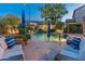 Relaxing pool area featuring lush landscaping, a tranquil waterfall, and cozy lounge seating for ultimate outdoor enjoyment at 8447 W Tether Trl, Peoria, AZ 85383