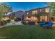 Spacious backyard featuring a pool, lush artificial turf, and cozy lounge chairs for ultimate relaxation and entertainment at 8447 W Tether Trl, Peoria, AZ 85383