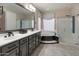 Bathroom featuring a double vanity, shower and tub combo, and a decorative window shade at 8447 W Tether Trl, Peoria, AZ 85383