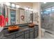 Modern bathroom featuring double sinks with granite countertops, black cabinets, and a walk-in shower at 8447 W Tether Trl, Peoria, AZ 85383