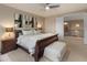 Well-lit bedroom featuring a cozy bed, side tables, and access to the upstairs hallway at 8447 W Tether Trl, Peoria, AZ 85383