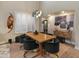 Dining room featuring natural wood table, modern chandelier, art display, plantation shutters and hardwood floors at 8447 W Tether Trl, Peoria, AZ 85383