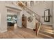 A welcoming entryway offers wood floors, staircase with dark iron railings, and views of a living space at 8447 W Tether Trl, Peoria, AZ 85383