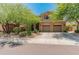 Charming two-story home showcasing a well-manicured lawn and a spacious three-car garage at 8447 W Tether Trl, Peoria, AZ 85383