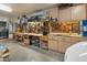 Organized garage featuring workbenches with tools and storage and a white EV at 8447 W Tether Trl, Peoria, AZ 85383
