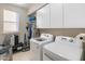Functional laundry room equipped with washer, dryer, storage, and natural light at 8447 W Tether Trl, Peoria, AZ 85383