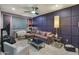 A cozy living room is showcased with a violet color scheme, a large sectional, and designer touches at 8447 W Tether Trl, Peoria, AZ 85383