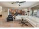 Living room open to kitchen features a white sectional sofa, wooden floors, and a large window with patio view at 8447 W Tether Trl, Peoria, AZ 85383