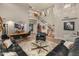 Spacious living room with staircase to second floor, wooden flooring, black leather sofas, clerestory windows, and a large chandelier at 8447 W Tether Trl, Peoria, AZ 85383