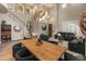 Bright, open-concept living area featuring a staircase, clerestory windows, and a wooden dining table with seating for six at 8447 W Tether Trl, Peoria, AZ 85383