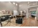 Open living room boasts high ceilings, clerestory windows, black leather sofas, and a nearby staircase to the second level at 8447 W Tether Trl, Peoria, AZ 85383