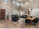 Bright living room featuring a dining table and modern black leather sofas in a high-ceilinged space with wooden floors at 8447 W Tether Trl, Peoria, AZ 85383
