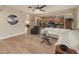 Light living room open to kitchen, features hardwood floors, a white L-shaped sofa, and clerestory windows at 8447 W Tether Trl, Peoria, AZ 85383