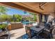 A covered outdoor patio featuring a ceiling fan, table, chairs, and backyard pool at 8447 W Tether Trl, Peoria, AZ 85383