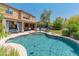 Relaxing pool with lounge areas, lush landscaping, and a charming two-story home as a backdrop, perfect for outdoor entertaining at 8447 W Tether Trl, Peoria, AZ 85383
