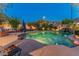 Charming pool area with a rock waterfall, lush greenery, and a cozy lounge area for relaxing evenings outdoors at 8447 W Tether Trl, Peoria, AZ 85383
