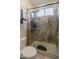 Bathroom shower with glass door, marble tile, shower head, and shower seat at 8447 W Tether Trl, Peoria, AZ 85383