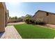 Backyard featuring green artificial turf, desert landscaping, and privacy wall at 8758 W Hayward Ave, Glendale, AZ 85305