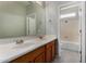Bathroom with a double sink vanity with a large mirror and a view into the shower/toilet room at 8758 W Hayward Ave, Glendale, AZ 85305