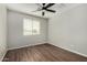 Bright bedroom features a ceiling fan, a window with blinds, and sleek hardwood floors at 8758 W Hayward Ave, Glendale, AZ 85305