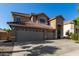 Two-story home showcasing a spacious driveway, three-car garage, and a red tile roof under a clear blue sky at 8758 W Hayward Ave, Glendale, AZ 85305