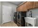 A functional laundry room with modern washer and dryer and ample storage at 8758 W Hayward Ave, Glendale, AZ 85305