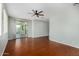 Spacious living room featuring hardwood floors, a ceiling fan, and a sliding glass door leading to the patio at 8758 W Hayward Ave, Glendale, AZ 85305