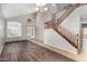 Bright living room featuring high ceilings, wood flooring, and a staircase with wooden banister at 8758 W Hayward Ave, Glendale, AZ 85305