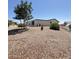 View of the rear of the home with desert landscaping and mature trees for shade at 8840 E Sunland Ave # 142, Mesa, AZ 85208