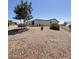 View of home's backyard showing desert landscaping and neutral colored home at 8840 E Sunland Ave # 142, Mesa, AZ 85208